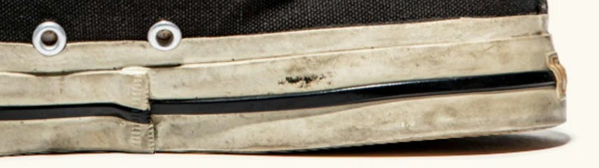 Side view of the cream rubber foxing stripe wrapping the join of canvas upper and sole.