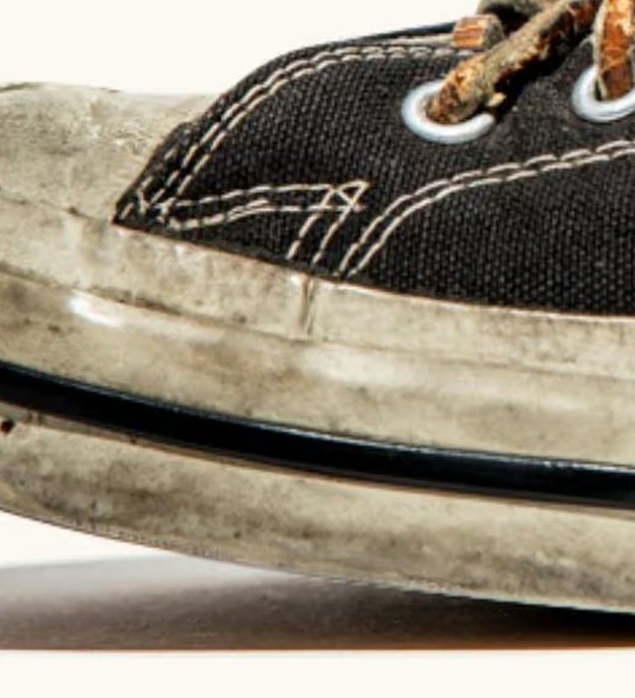 Close view of the worn rubber toe cap and the foxing wrapped around it